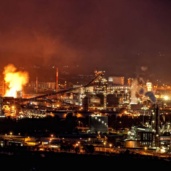Industrieanlage bei Nacht mit Feuerschein. (Symbolbild)
