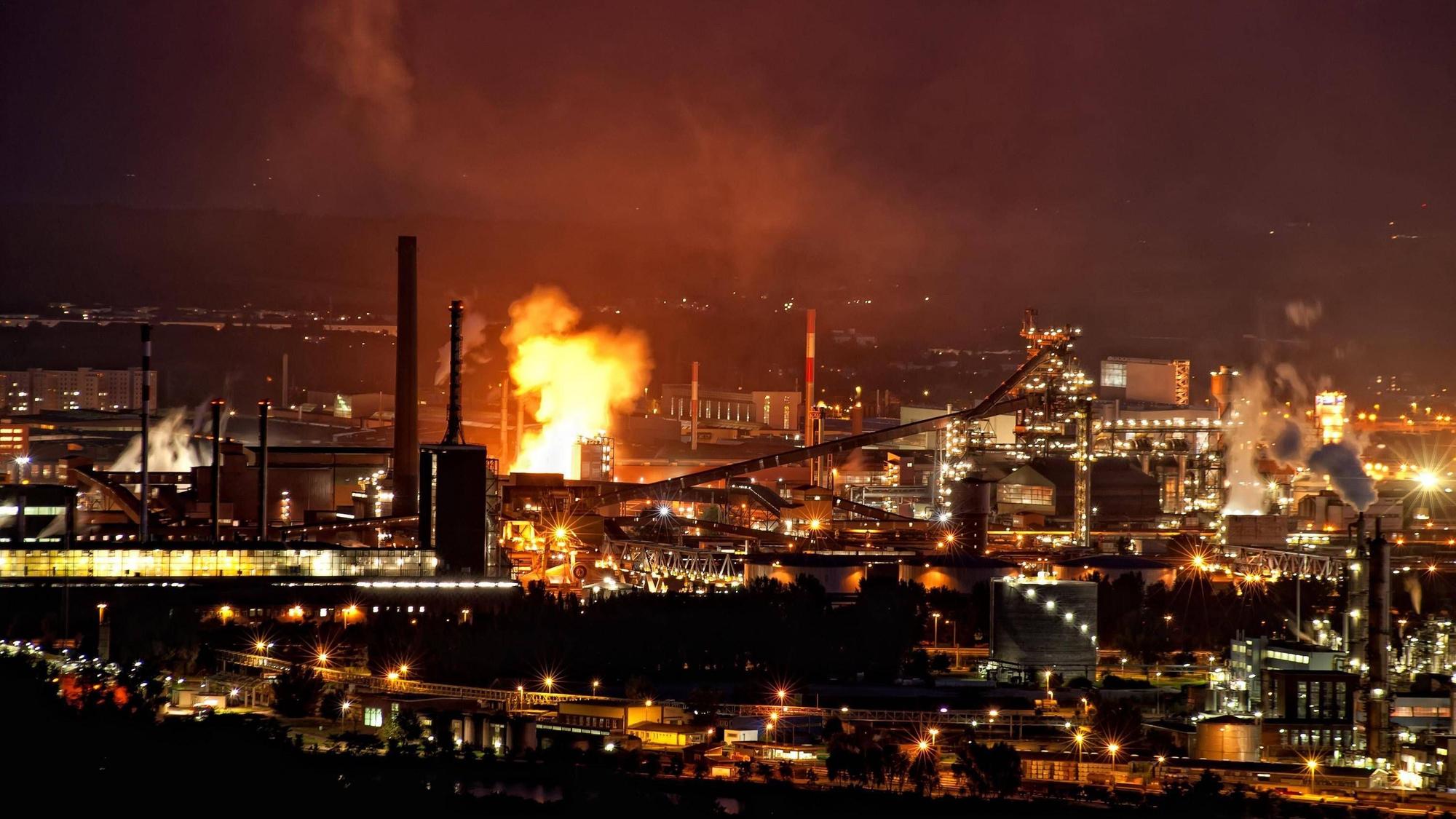 Industrieanlage bei Nacht mit Feuerschein. (Symbolbild)