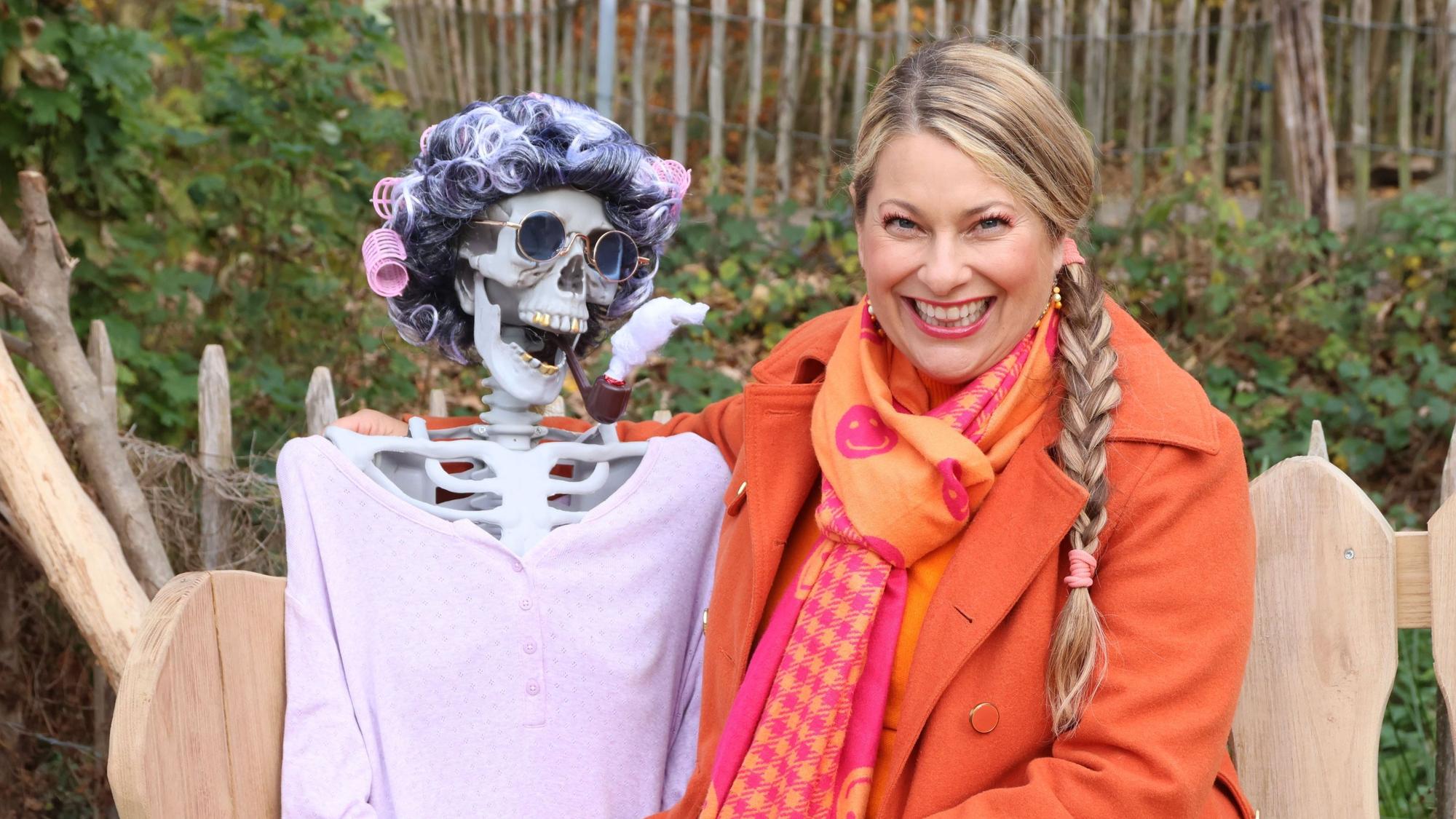 Das Foto zeigt die Fernsehmoderatorin Manuela Klein mit einer gruseligen Skelett-Puppe mit Locknwicklern.