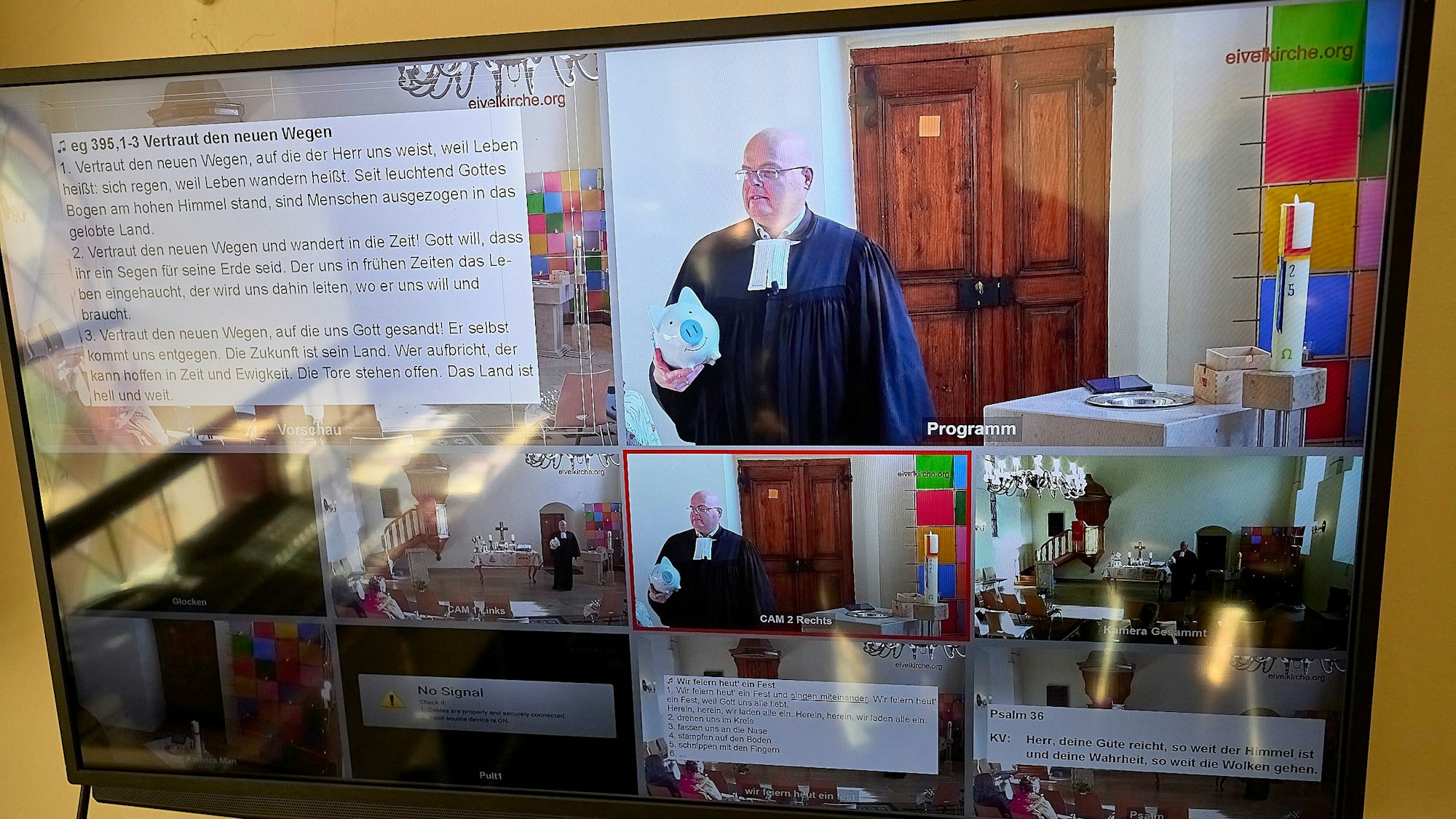 Auf einem Computermonitor sind verschiedene Bilder aus der Übertragung eines Gottesdienstes in Hellenthal zu sehen.