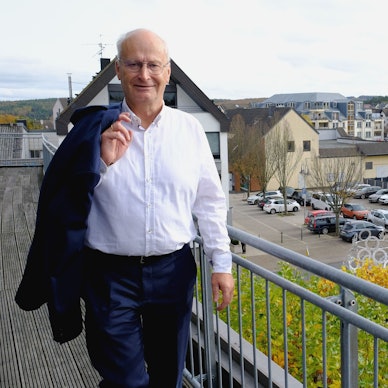 Bürgermeister Dr. Hans-Peter Schick steht mit leger über die Schulter geworfenem Jackett auf dem Rathausbalkon. Im Hintergrund ist die Mechernicher Innenstadt zu sehen.