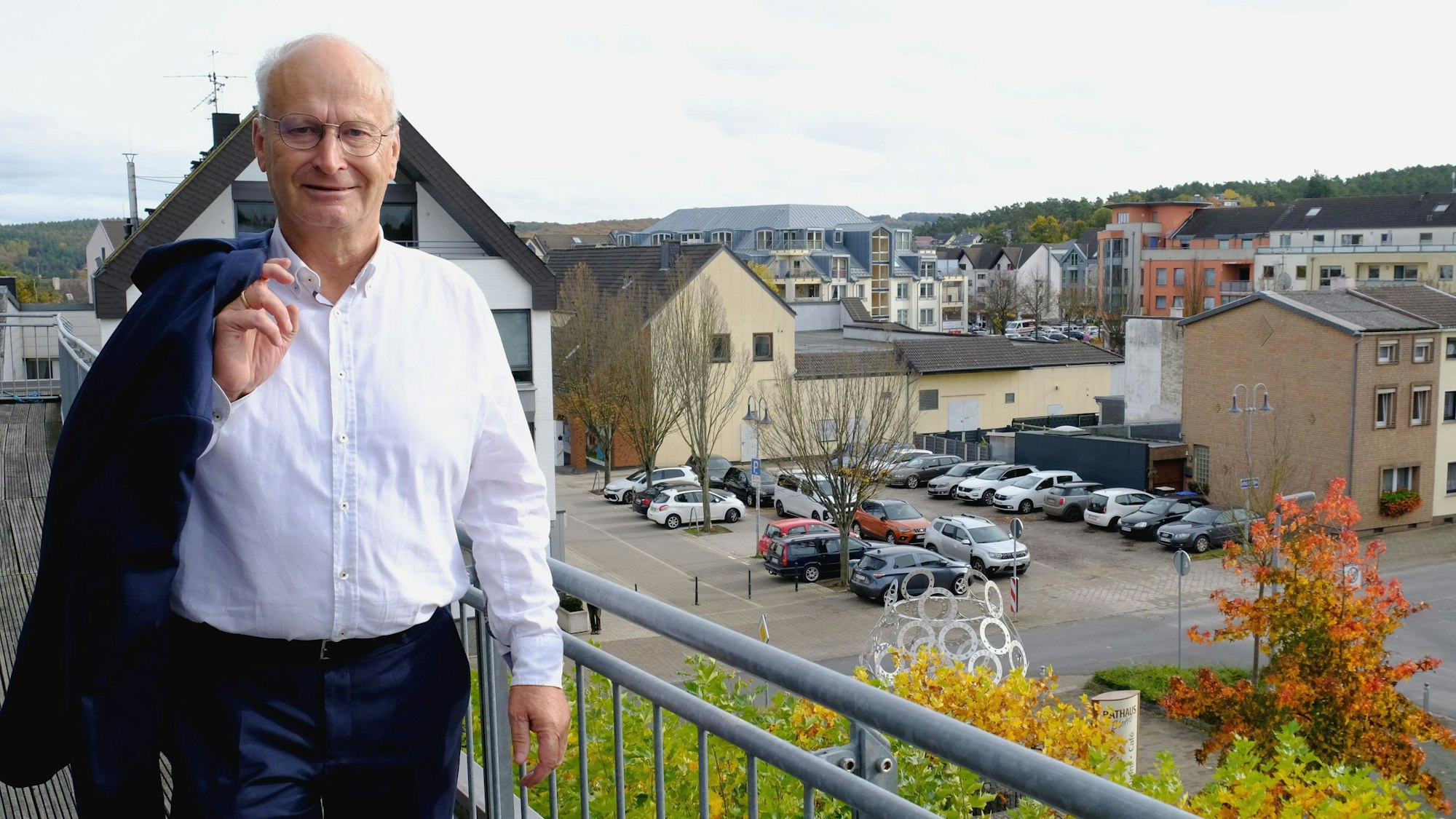 Bürgermeister Dr. Hans-Peter Schick steht mit leger über die Schulter geworfenem Jackett auf dem Rathausbalkon. Im Hintergrund ist die Mechernicher Innenstadt zu sehen.