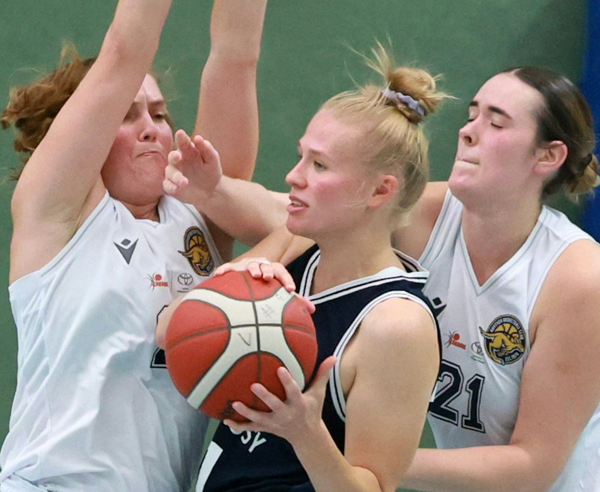Das Foto zeigt zwei Basketballerinnen, die der Gegnerin den Ball abnehmen wollen.