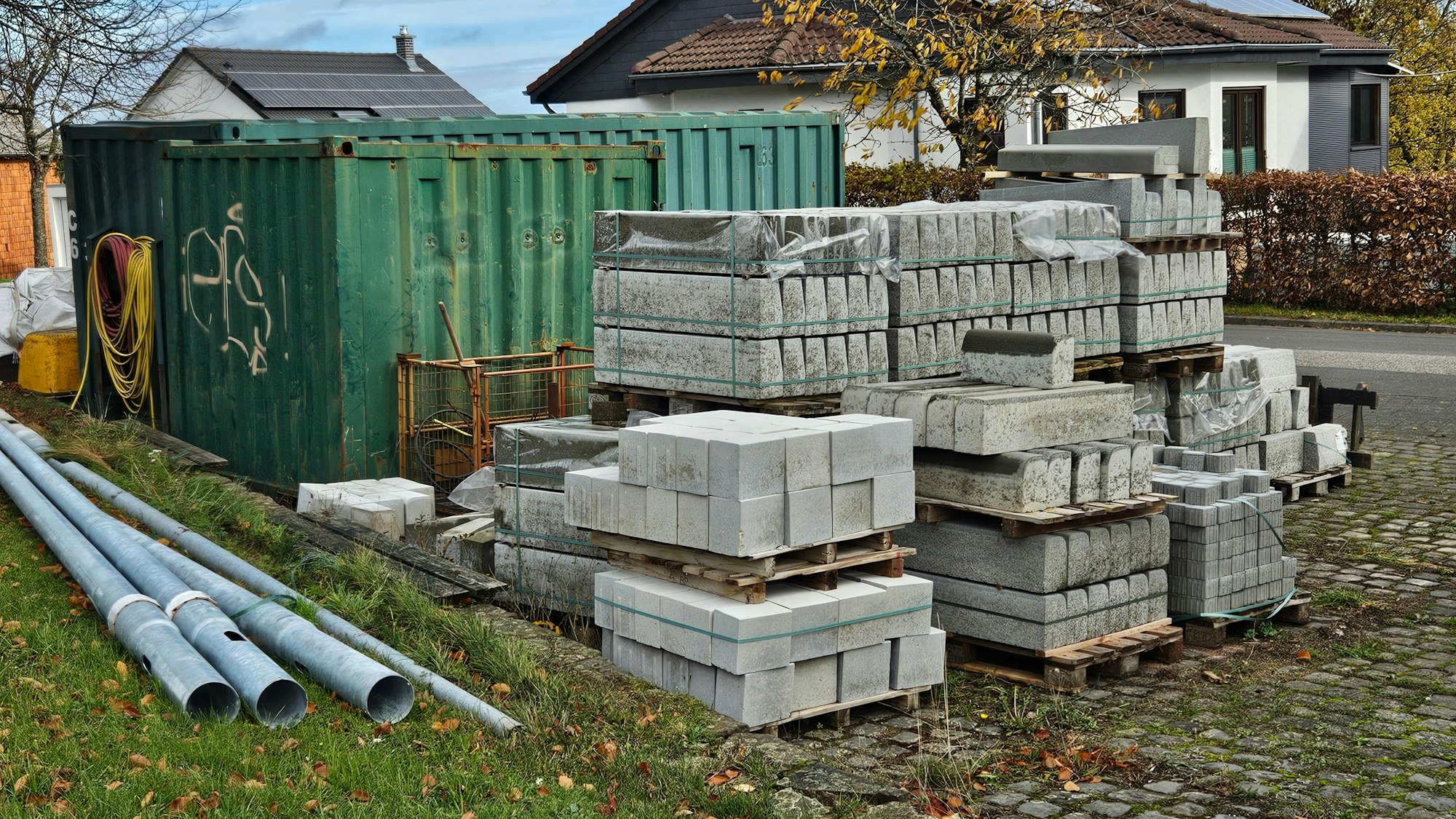 Das Foto zeigt gestapelte Randsteine und mehrere Container.