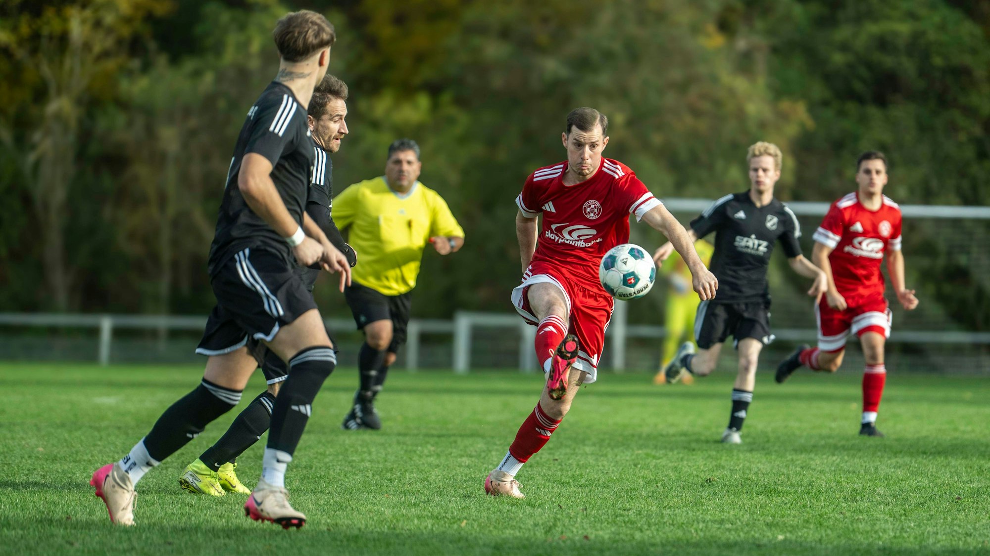 Beobachtet von zwei Frauenberger Spielern spielt Zülpichs Daniel Esser einen langen Ball.