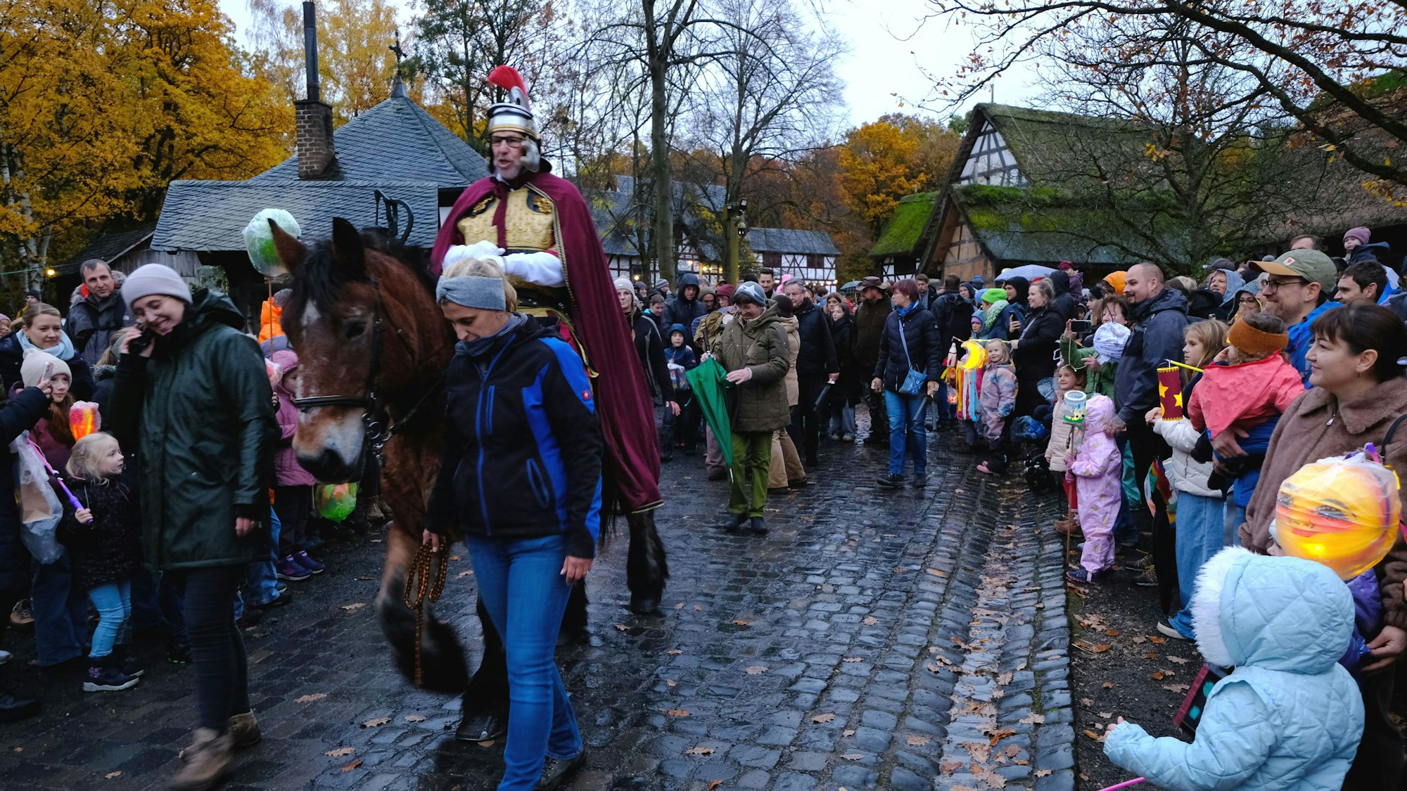 Martinszug im LVR-Freilichtmuseum Kommern: Sankt Martin reitet an den Teilnehmern des Laternenzuges vorbei.