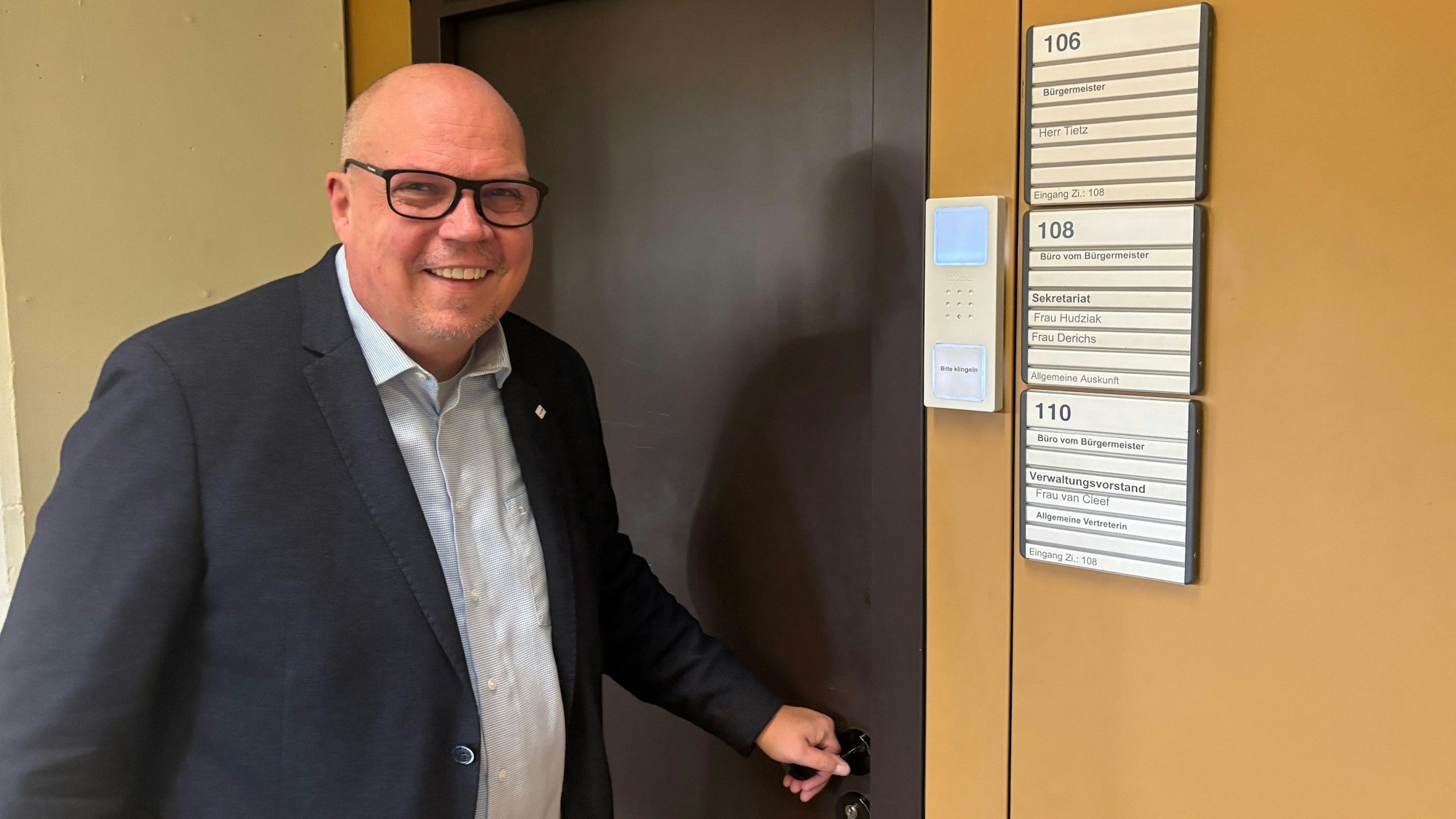 Ein Mann steht vor einer Tür, die zu einem Büro führt.