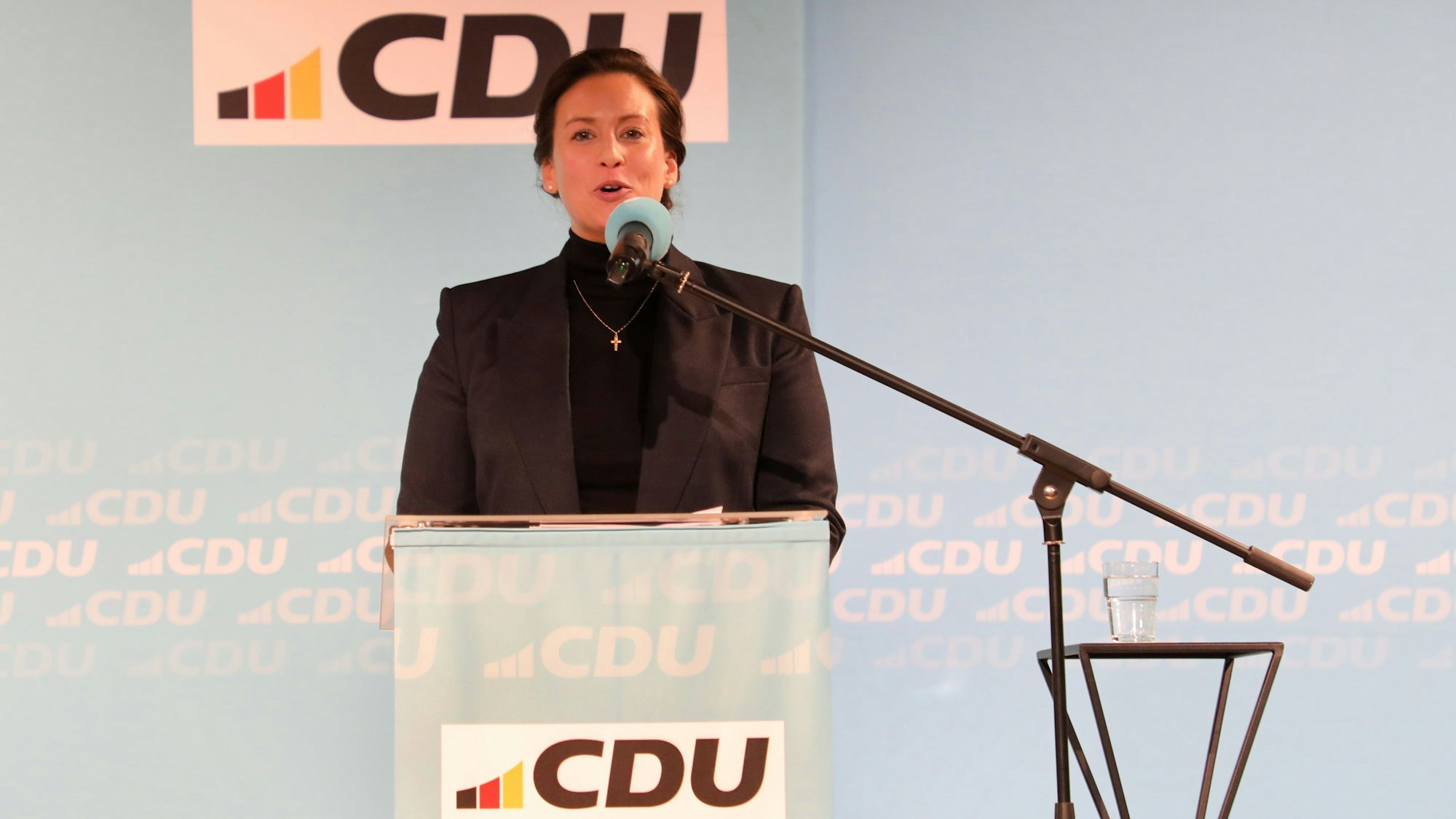 Caroline Bosbach steht am Mikrofon vor einer Wand mit CDU-Signet.