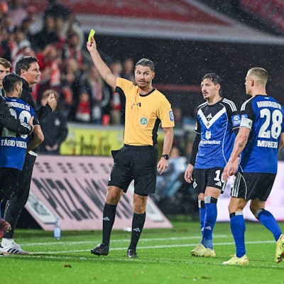 Schiedsrichter Daniel Schlager zeigt Trainer Merlin Polzin Hamburger SV die gelbe Karte