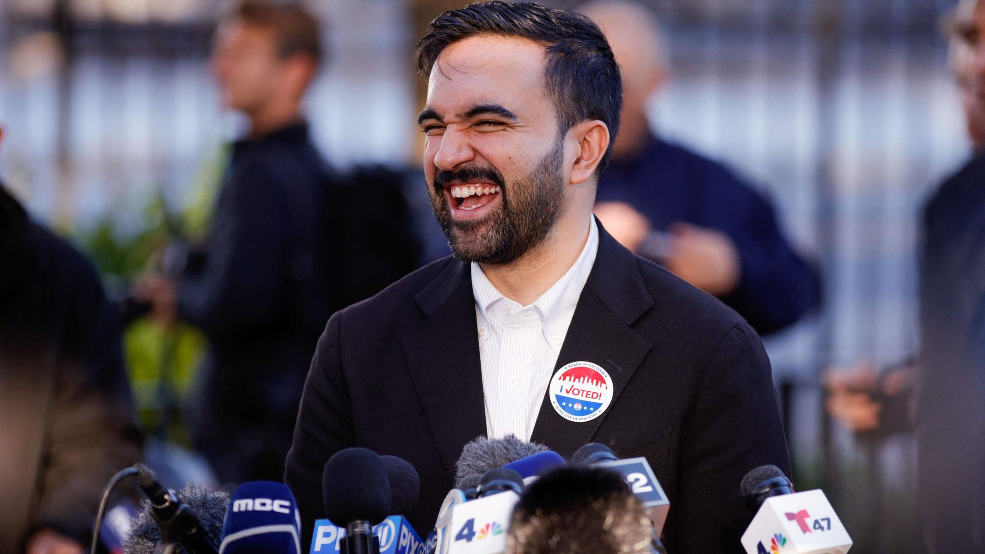 Der demokratische Kandidat Zohran Mamdani lacht im Gespräch mit Reportern - und geht als Favorit in die New Yorker Bürgermeisterwahl. (Archivbild)