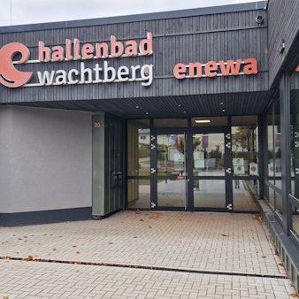 Trotz Mehrkosten und Bauverzögerungen blättert noch die Beschriftung am zu sanierenden Wachtberger Hallenbad. Wann geöffnet wird, ist immer noch fraglich.