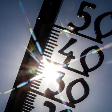 Vor einem wolkenlosen blauen Himmel zeigt ein Außenthermometer in einem Garten bereits am Vormittag über 30 Grad Lufttemperatur an. (Symbolbild)