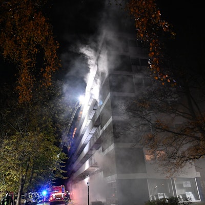 Rauchwolken kommen aus einem Mehrfamilienhaus.
