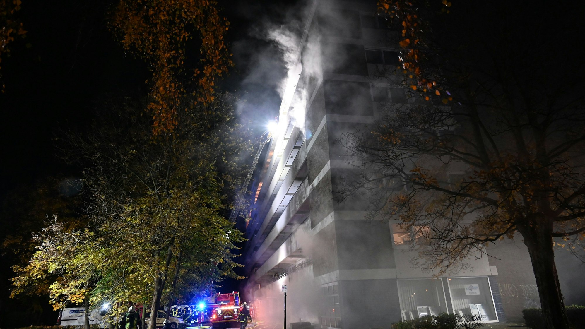 Rauchwolken kommen aus einem Mehrfamilienhaus.