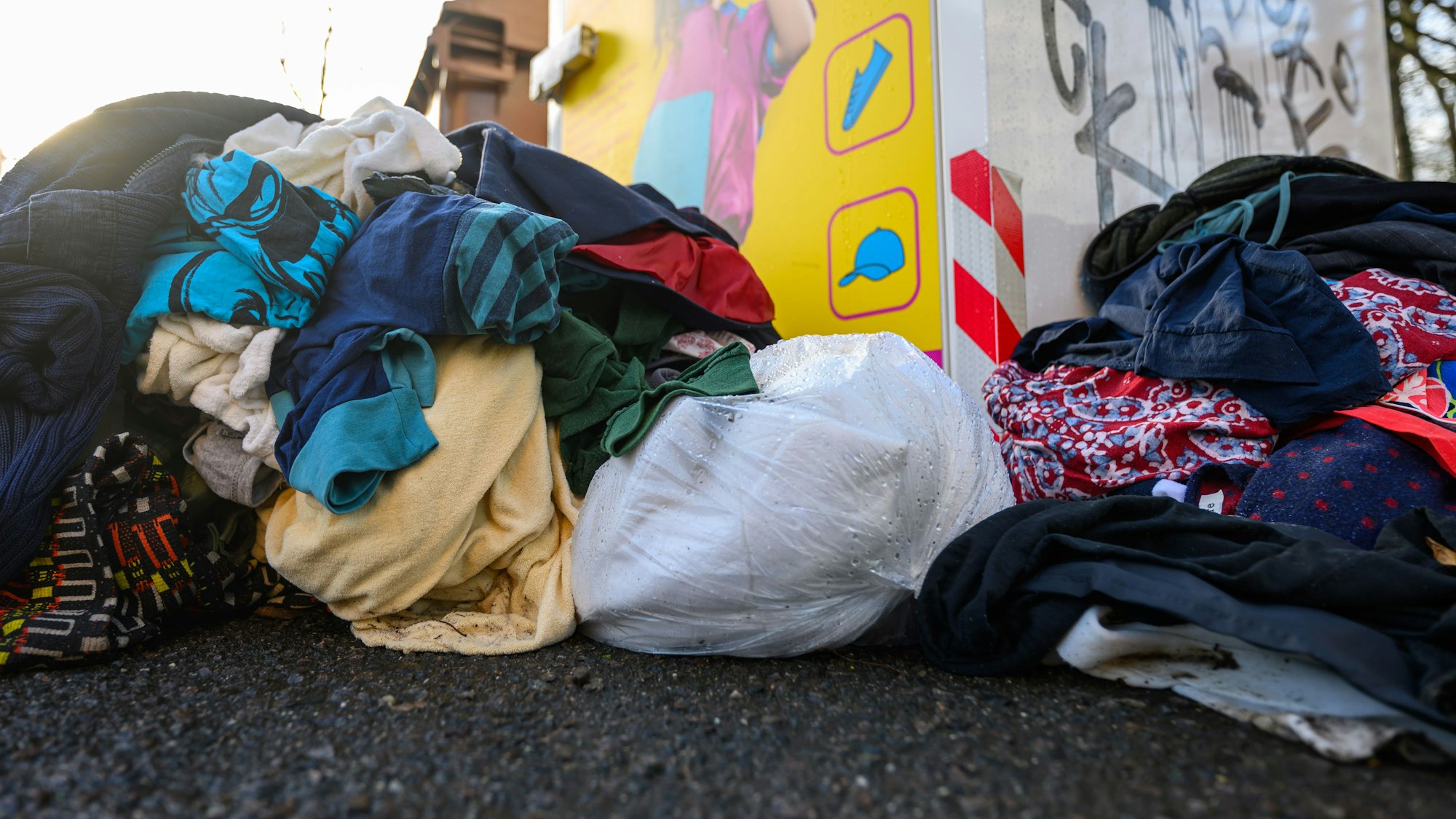 Rund um Altkleider-Container stapeln sich die Kleidungsstücke und manche schmeißen auch Müll in die Container.