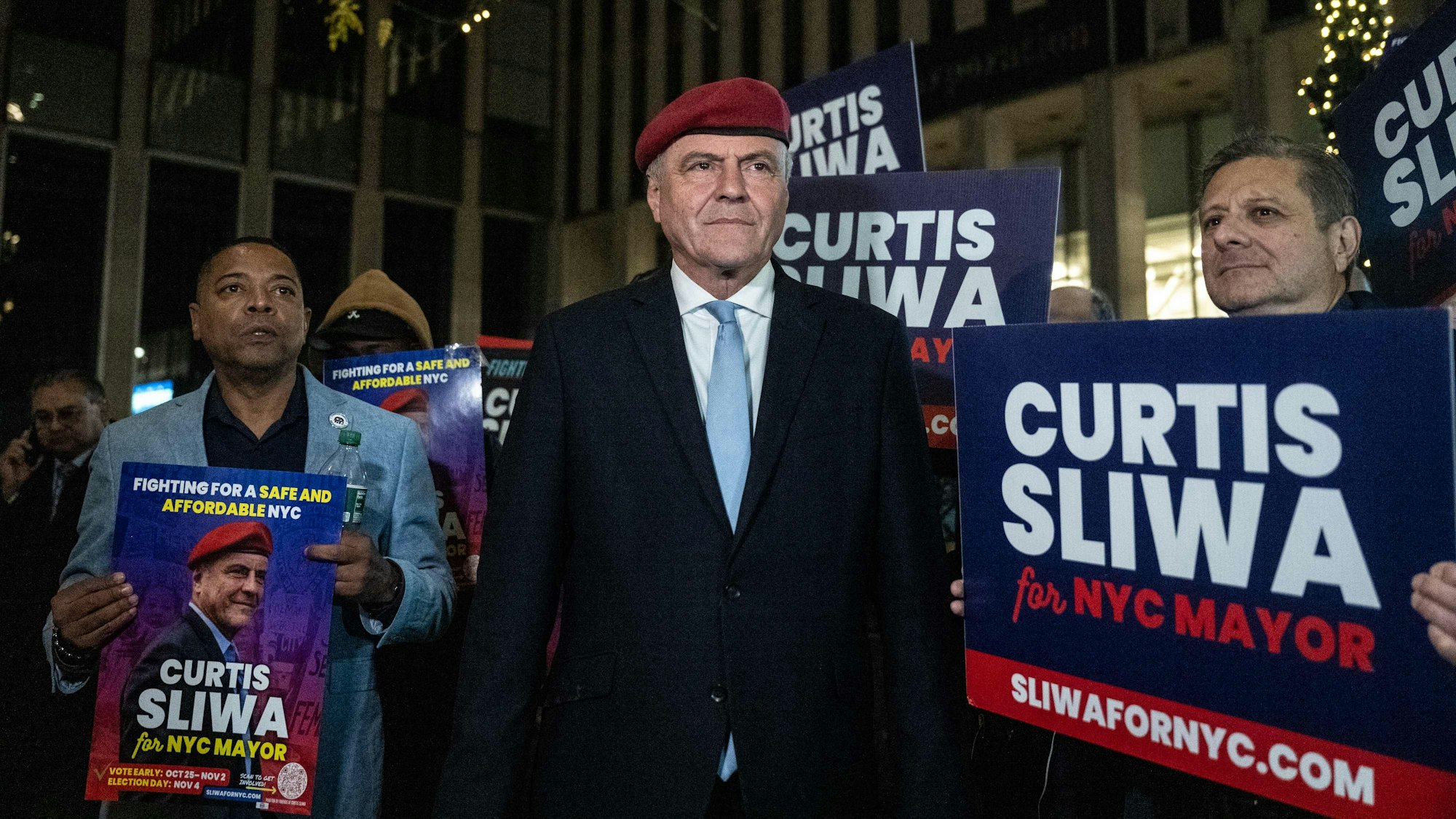 Curtis Sliwa steht zwischen Wahplakaten.