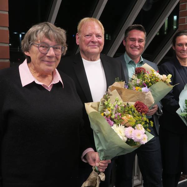 Zwei Frauen und zwei Männer stehen mit Blumensträußen in der Hand nebeneinander.