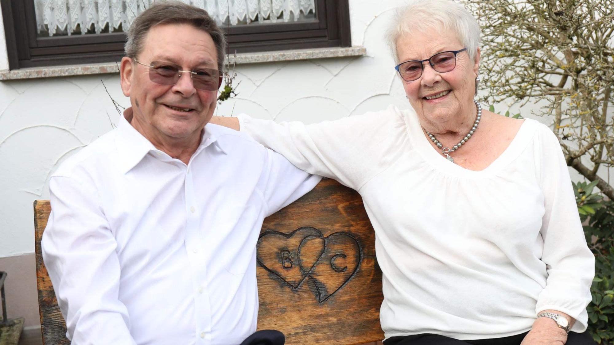 Ein Mann und eine Frau auf einer Holzbank.
