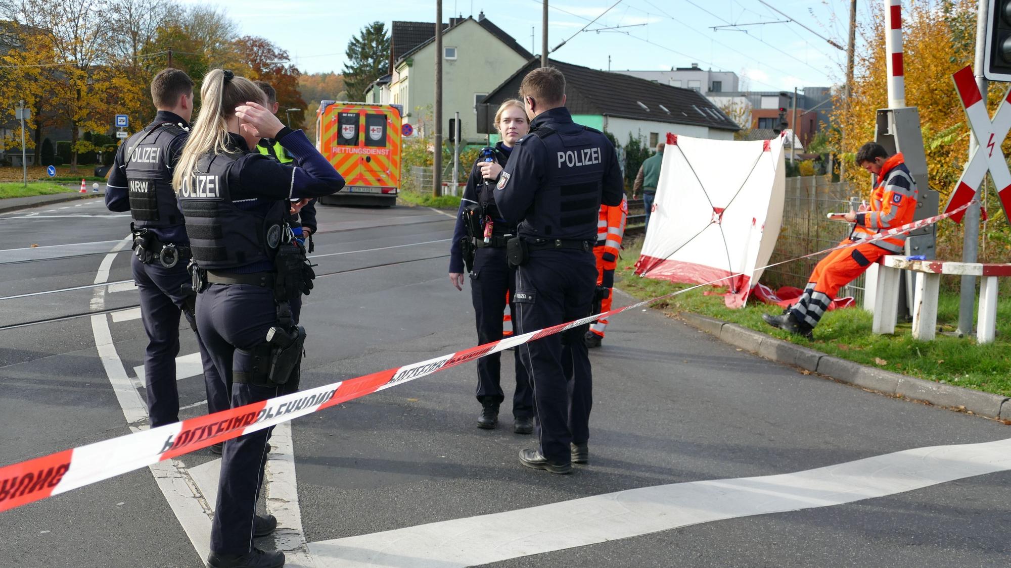 Einsatzkräfte stehen am Bahnübergang an der Bröltalstraße in Hennef.