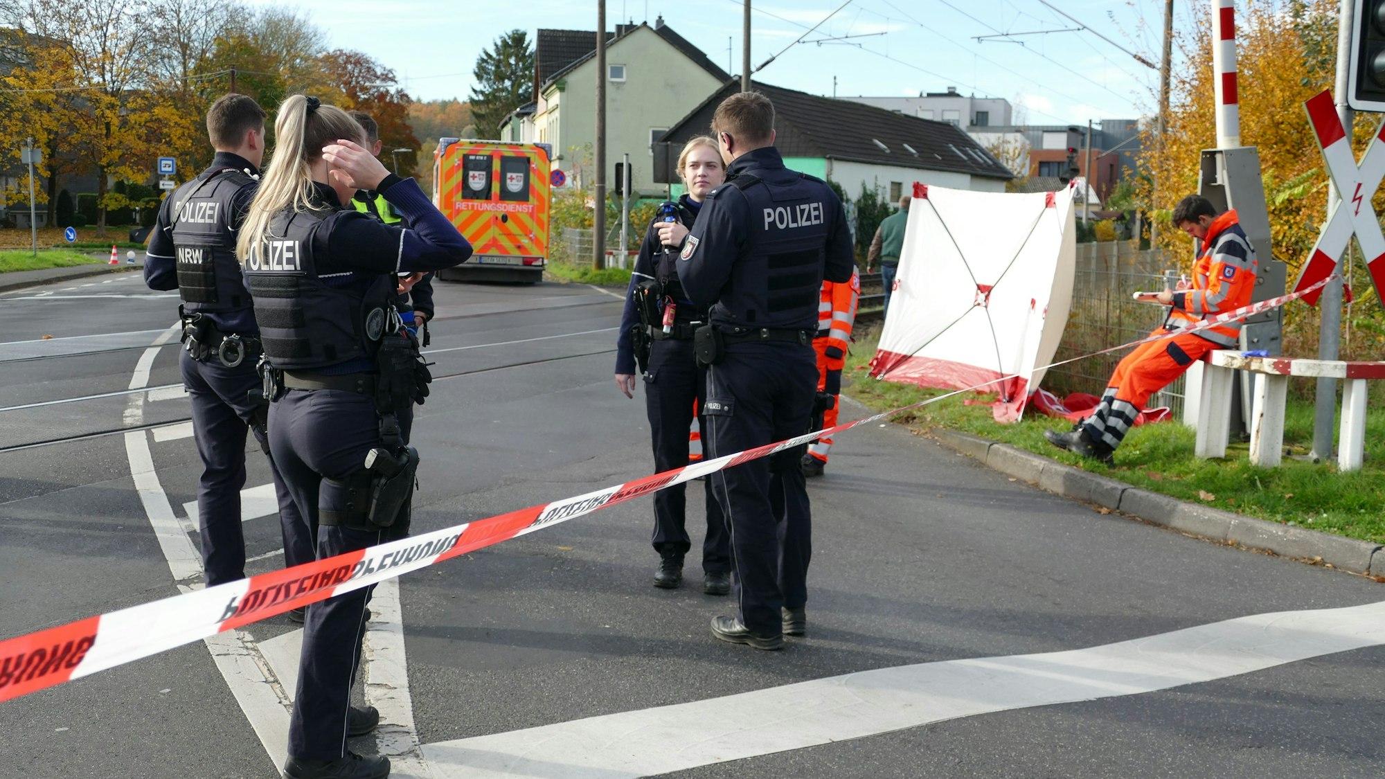 Einsatzkräfte stehen am Bahnübergang an der Bröltalstraße in Hennef.