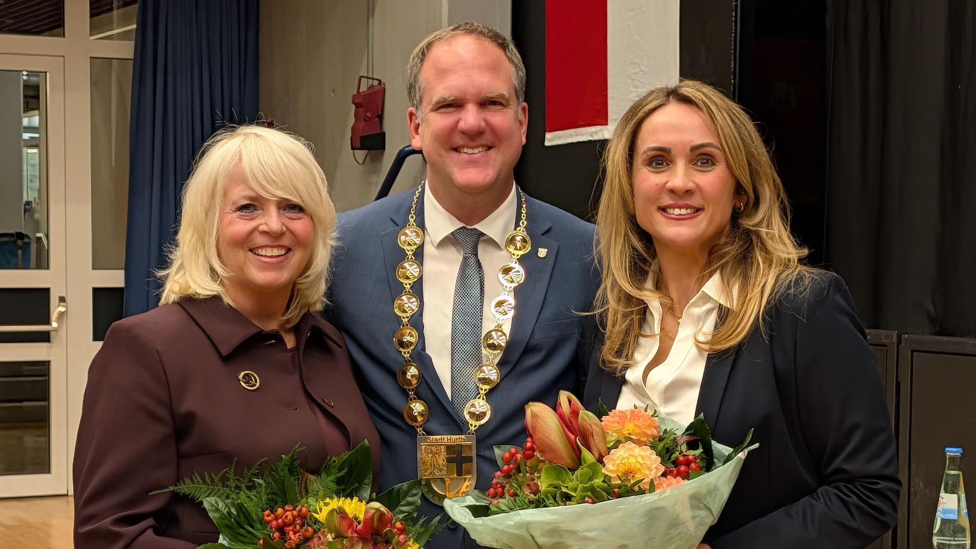 Das Foto zeigt die beiden neu gewählten Vizebürgermeisterinnen mit Blumensträußen und den Bürgermeister mit Amtskette.