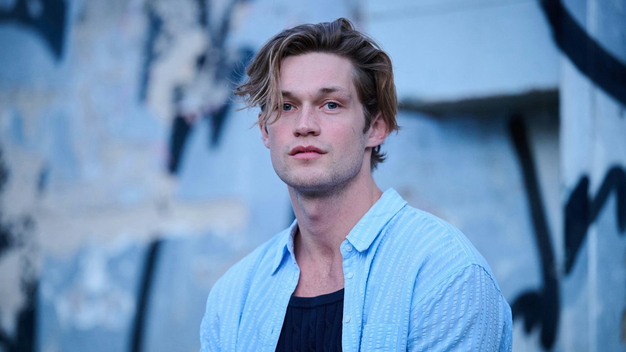 Ein Mann blickt verträumt in die Kamera.