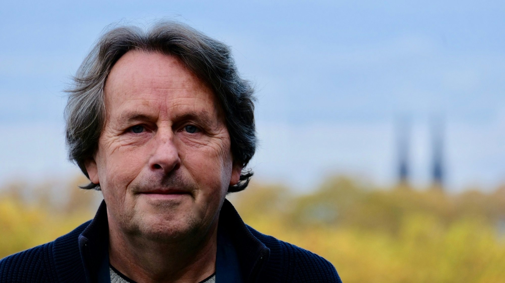 Ein Mann mit dunklem Haar schaut in die Kamera.