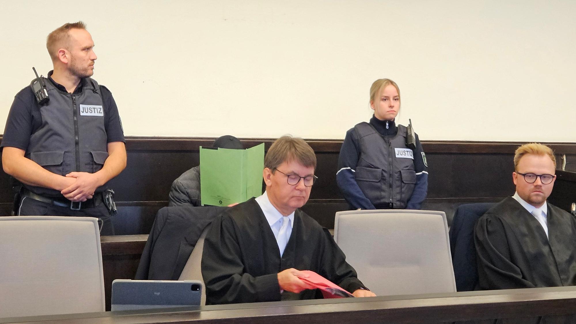 Anwälte, Polizisten und der Angeklagte im Gericht.