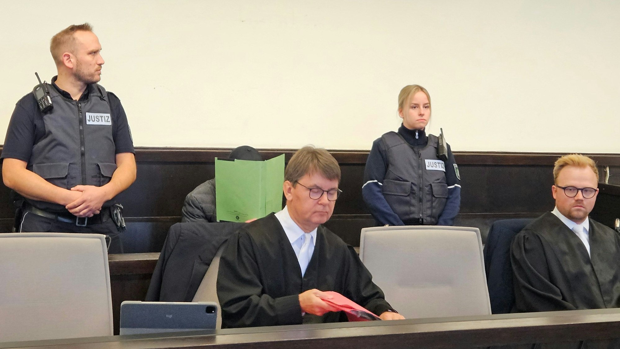 Anwälte, Polizisten und der Angeklagte im Gericht.