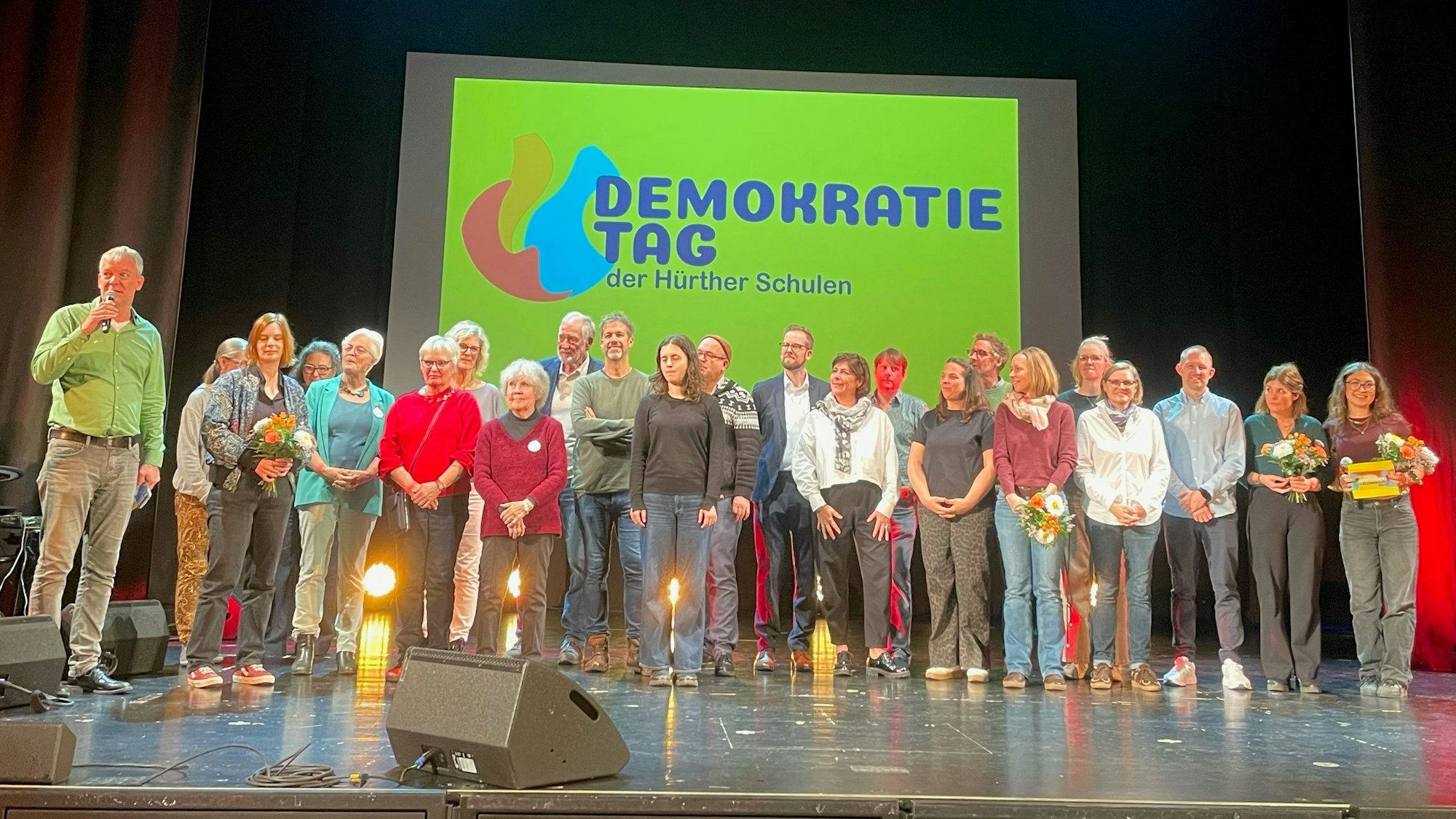 Das Foto zeigt eine Gruppe von Menschen auf der Bühne im Hürther Bürgerhaus.