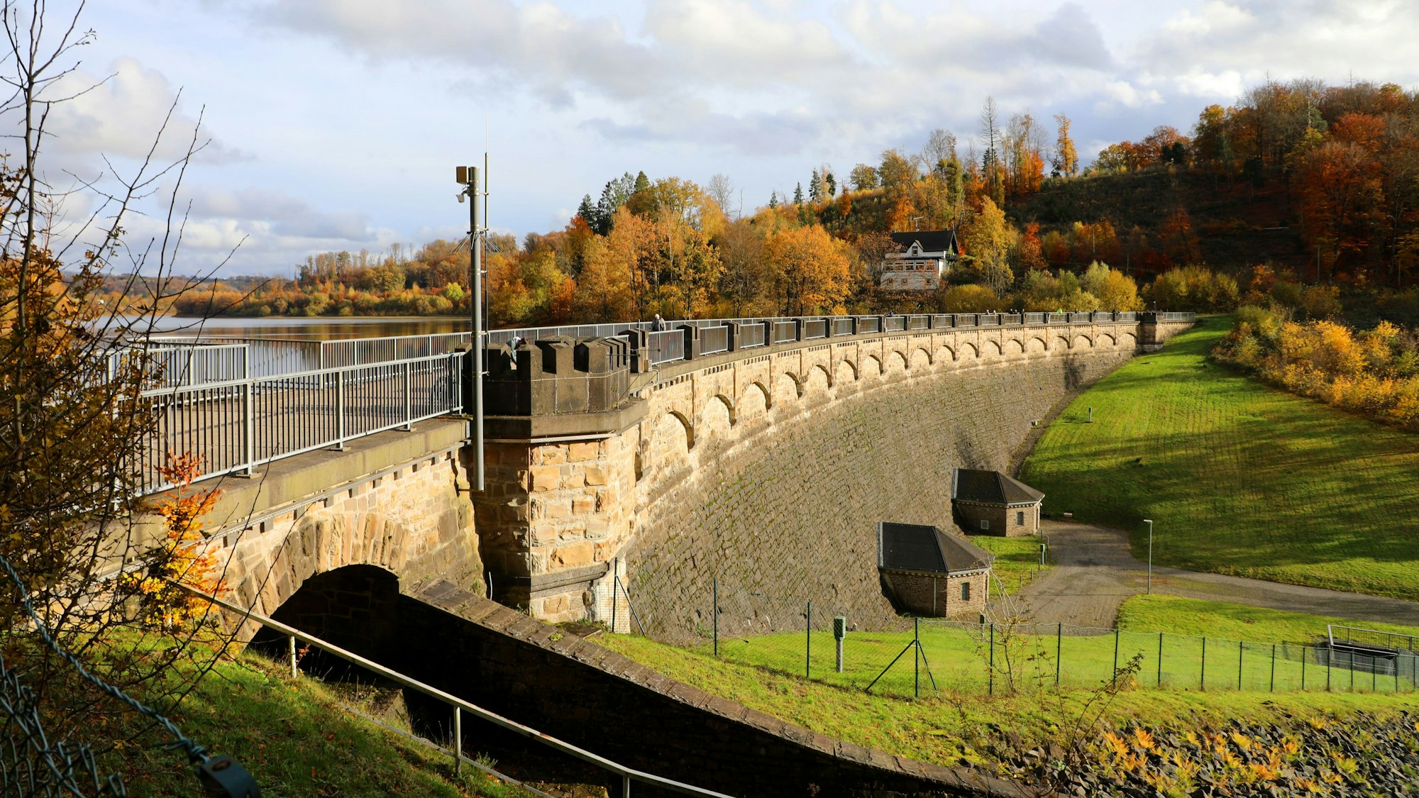 Die Staumauer der Lingesetalsperre liegt in der Nachmittagsherbstsonne.