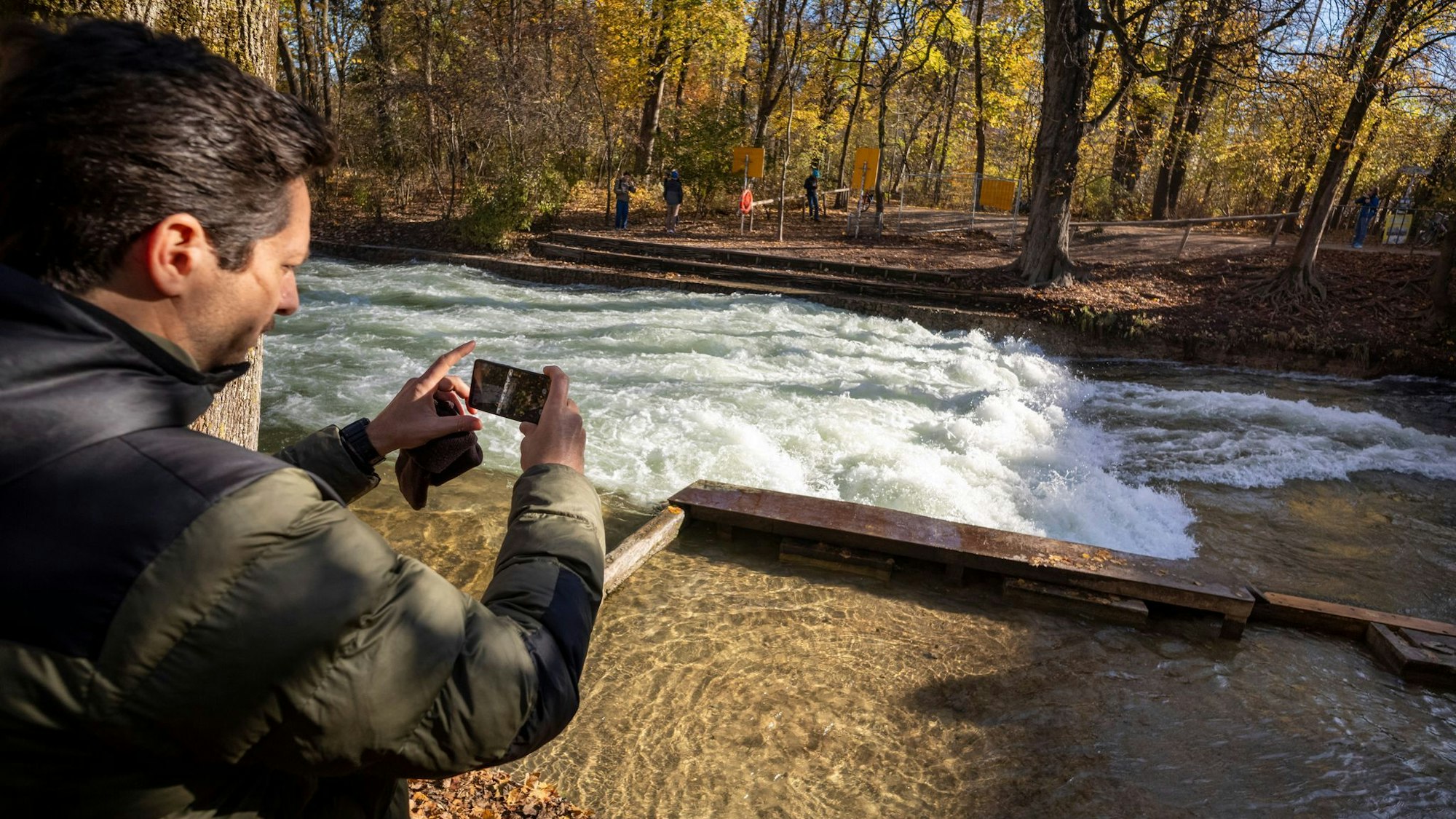 Freizeitsurfer Alexander Neumann fotografiert die - zurzeit nicht funktionstüchtige - Eisbachwelle im Englischen Garten.