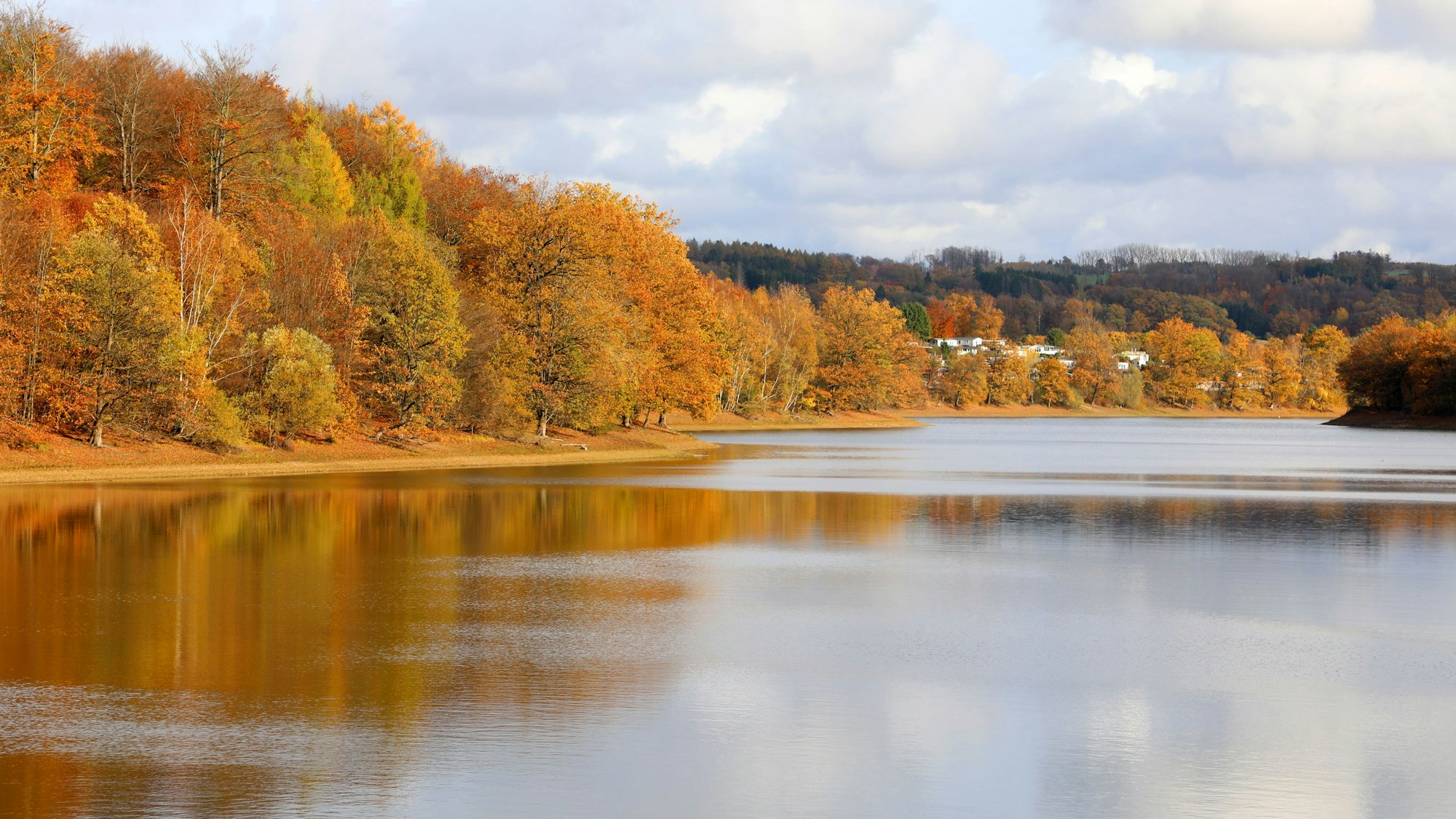 In der Nachmittagssonne erstrahlt die Lingesetalsperre von der Staumauer aus gesehen.