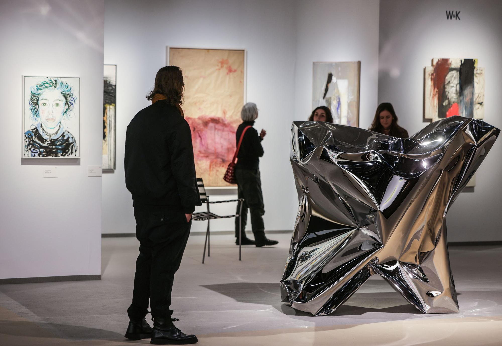 Besucher gehen über die Stände der Galerien auf Kunstmesse