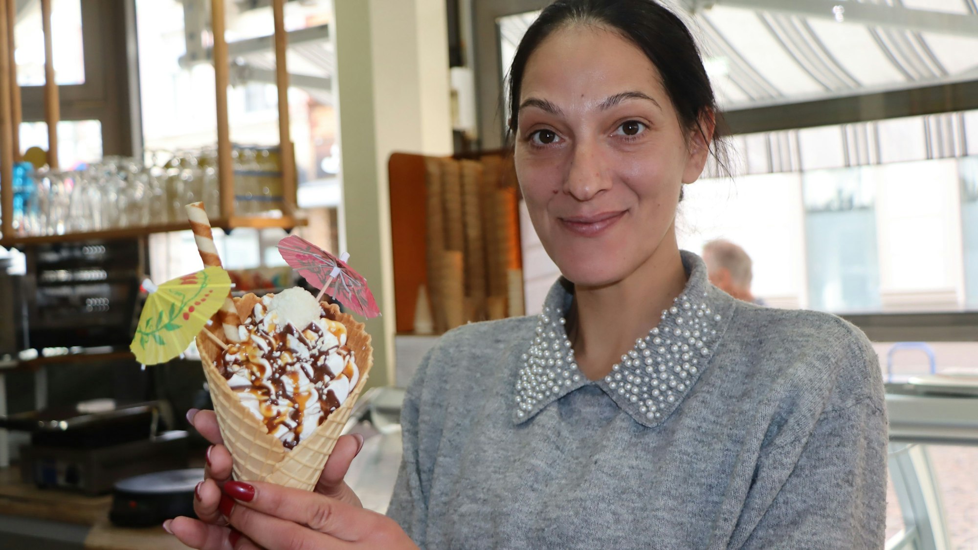 Das Foto zeigt eine Frau mit einer Eistüte in der Hand.