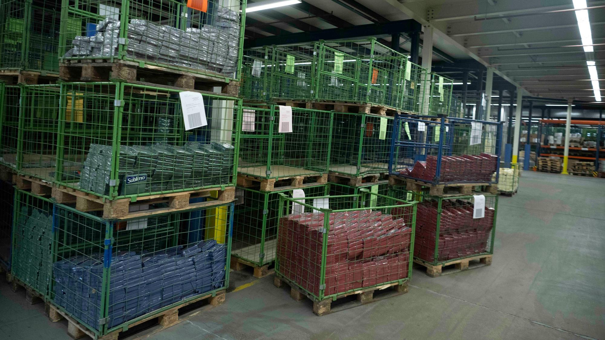 Das Bild zeigt einige grüne Metallkörbe, die entweder leer sind oder in denen einige verpackte Servietten liegen.