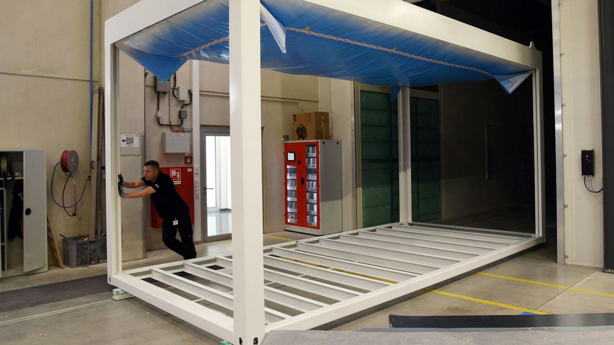 Von Hand und nahezu mühelos schiebt Vorarbeiter Daniel Hähner bei Pro-Contain in Morsbach-Lichtenberg ein Containergerippe aus einer der Lackierstraßen. 2,3 Kilometer misst das Schienennetz in der Halle. Unser Foto zeigt den Mann bei der Arbeit.