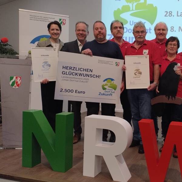 Das Bild zeigt die Abordnungen aus Oberwiehl (in rot) und Hülsenbusch mit der NRW-Ministerin Silke Gorißen (links), Oberbergs Landrat Klaus Grootens (Zweiter von links) und Wiehls Bürgermeister Ulrich Stücker (rechts). Auf dem Bild fehlt Heike Brand.