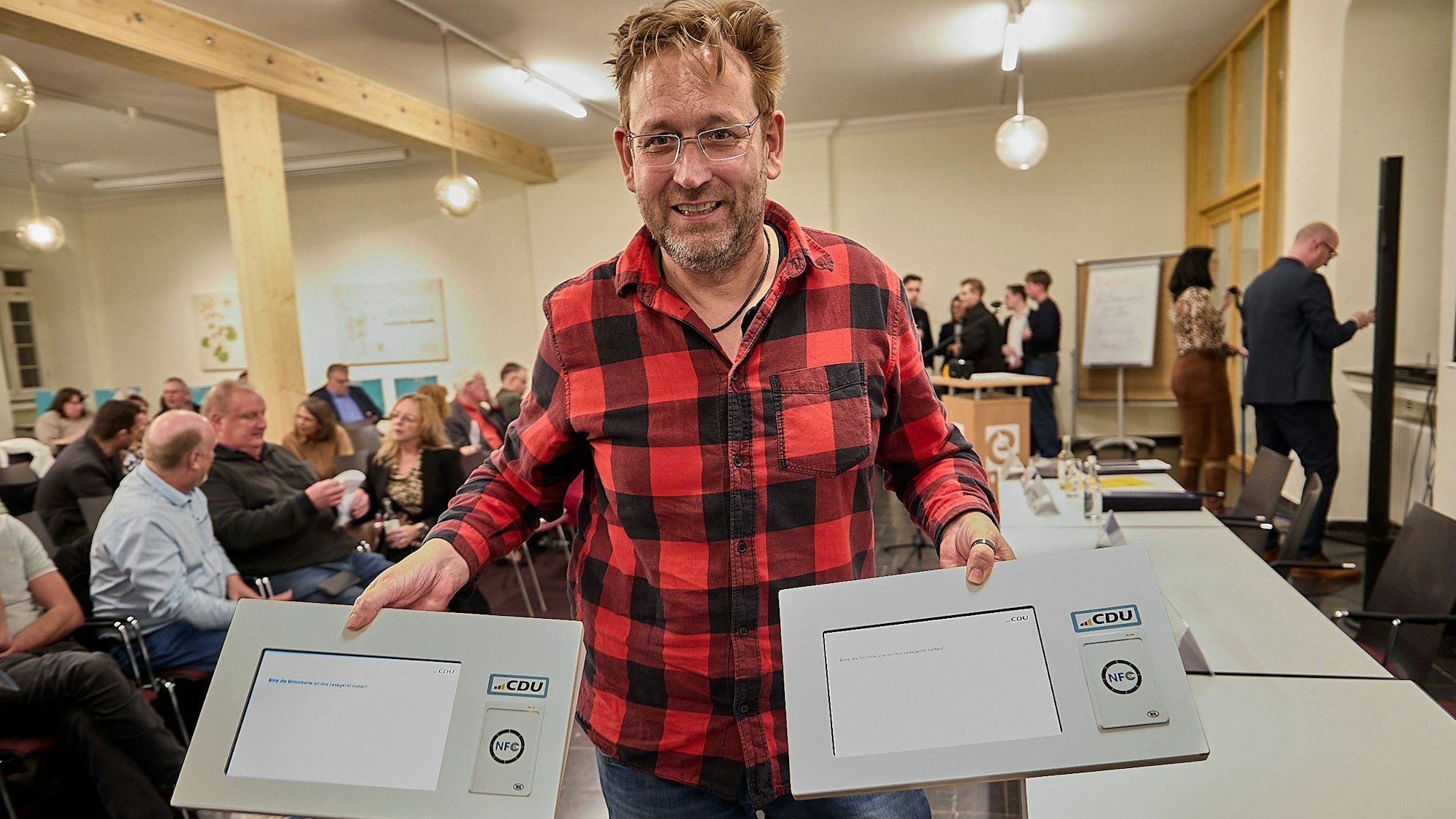 Holstätter hält zwei Geräte in den Händen.