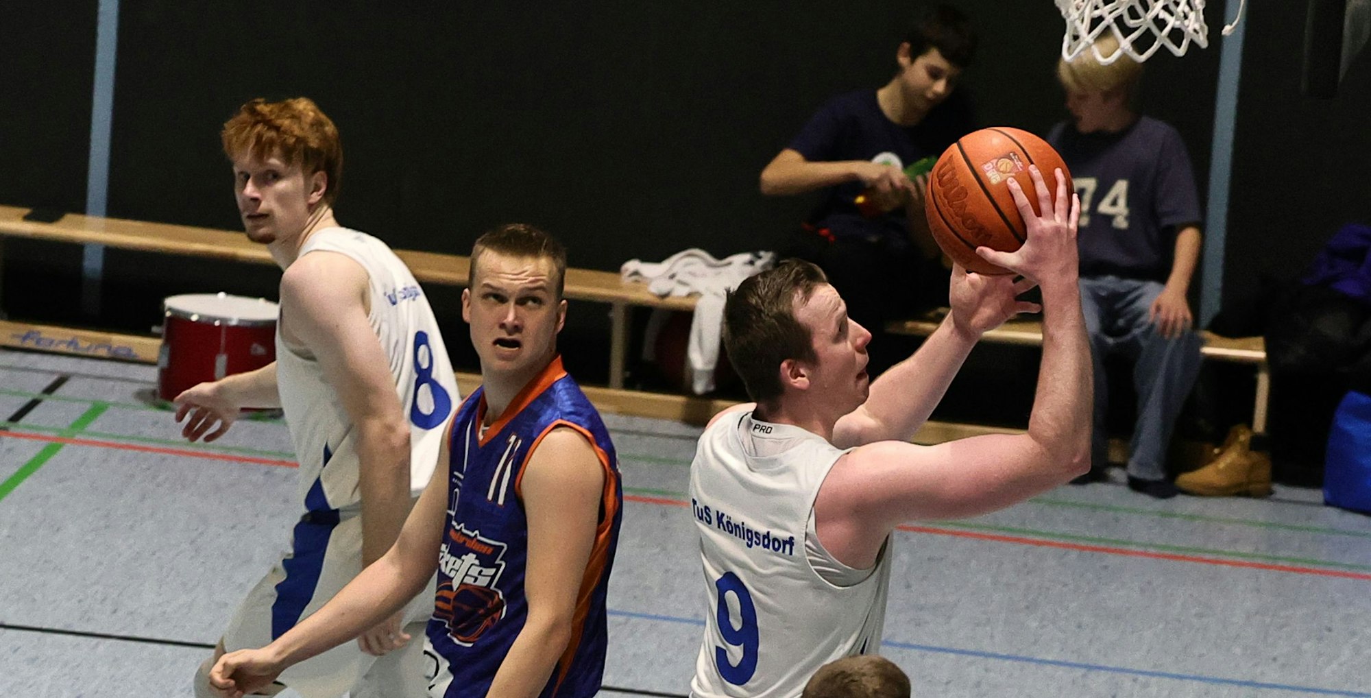 Das Foto zeigt einen Königdorfer Basketballer, der mit Ball auf dem Weg zum Korb ist.