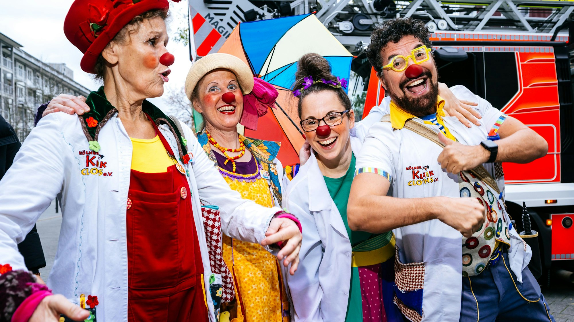 Zu sehen sind vier Kölner Klinik-Clowns beim Tanzen.