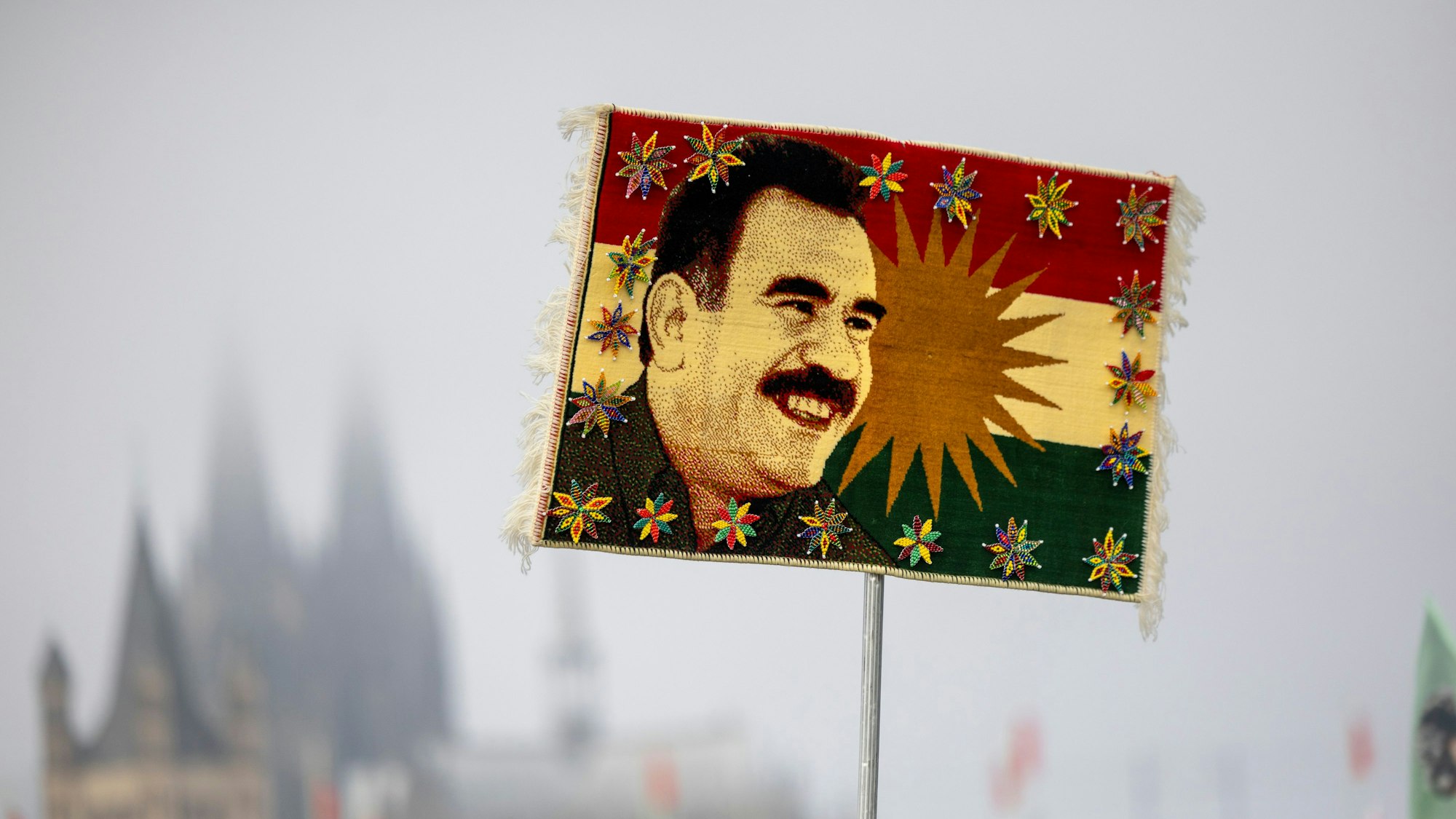 Ein Teilnehmer der kurdischen Großdemonstration hält einen Teppich mit dem Gesicht von Abdullah Öcalan, dem Gründer der PKK in die Höhe.