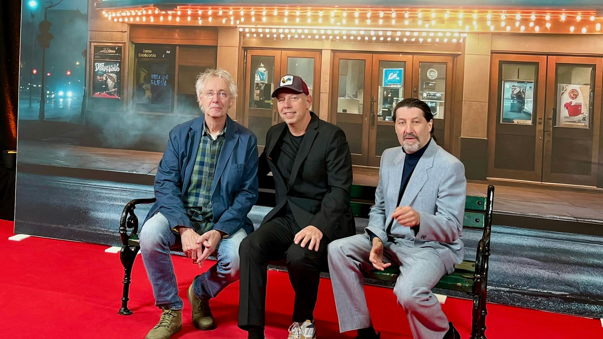 Das Foto zeigt die Vertreter der Preisträger auf einer Bank vor einer Kinokulisse.