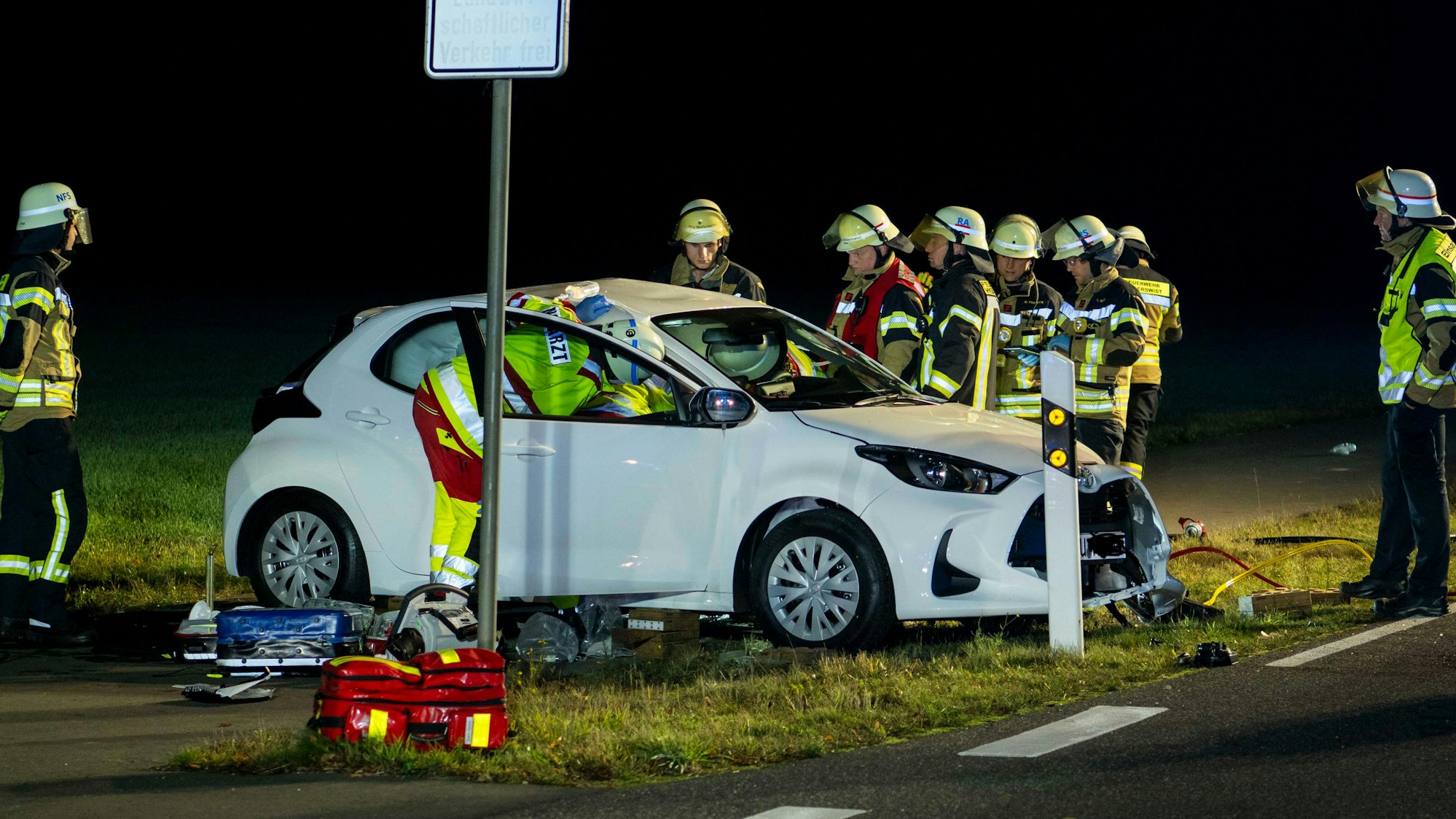 Feuerwehr und Rettungsdienst kümmern sich um die verunglückte Autofahrerin, deren Wagen neben der Fahrbahn zum Stehen gekommen ist.