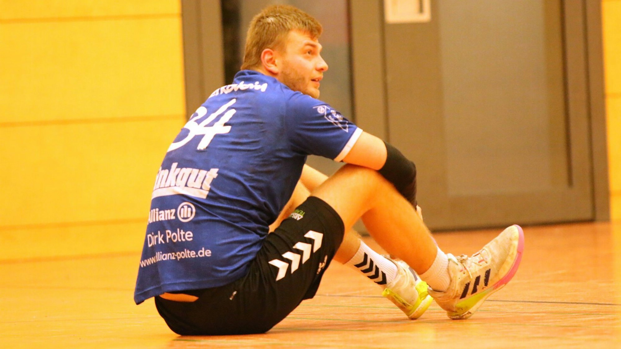 Fabian Horst sitzt auf dem Hallenboden.