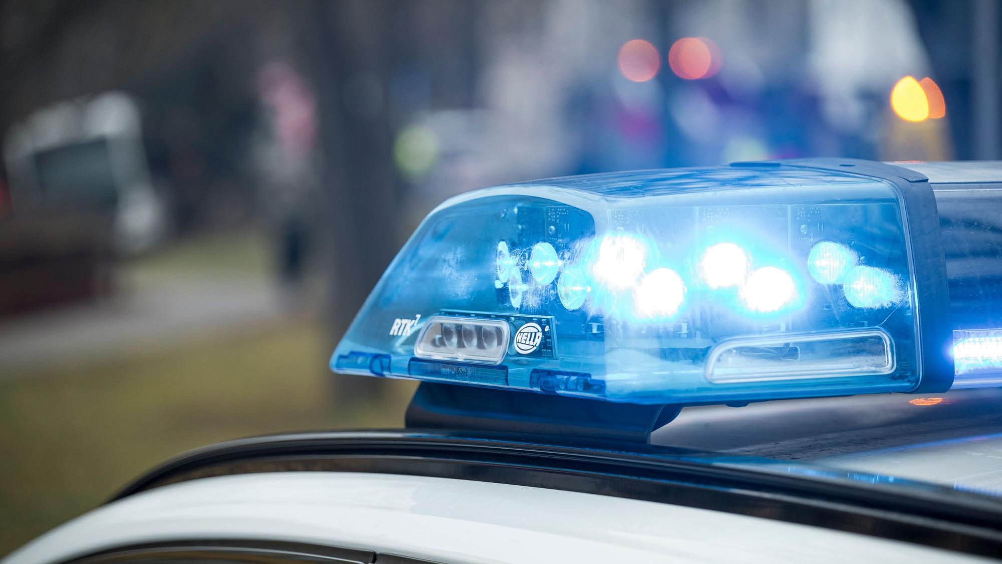 Blaulicht leuchtet auf einem Einsatzfahrzeug der Polizei am Unfallort.