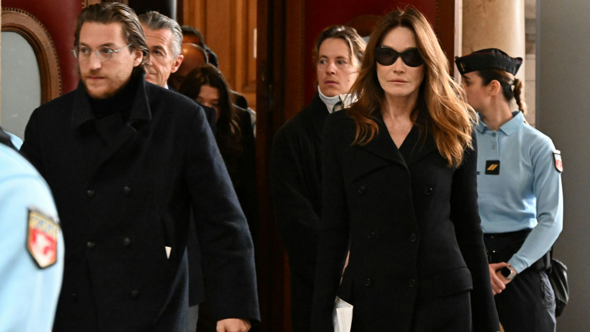 10.11.2025, Frankreich, Paris: Jean Sarkozy (l), Sohn des ehemaligen französischen Präsidenten Sarkozy, und Carla Bruni-Sarkozy, Ehefrau des ehemaligen französischen Präsidenten Sarkozy, verlasen ein Pariser Gericht. Das Berufungsgericht berät über einen Antrag von Frankreichs ehemaligem Präsidenten Sarkozy unter Auflagen frühzeitig das Gefängnis zu entlassen. Foto: Emma Da Silva/AP/dpa +++ dpa-Bildfunk +++