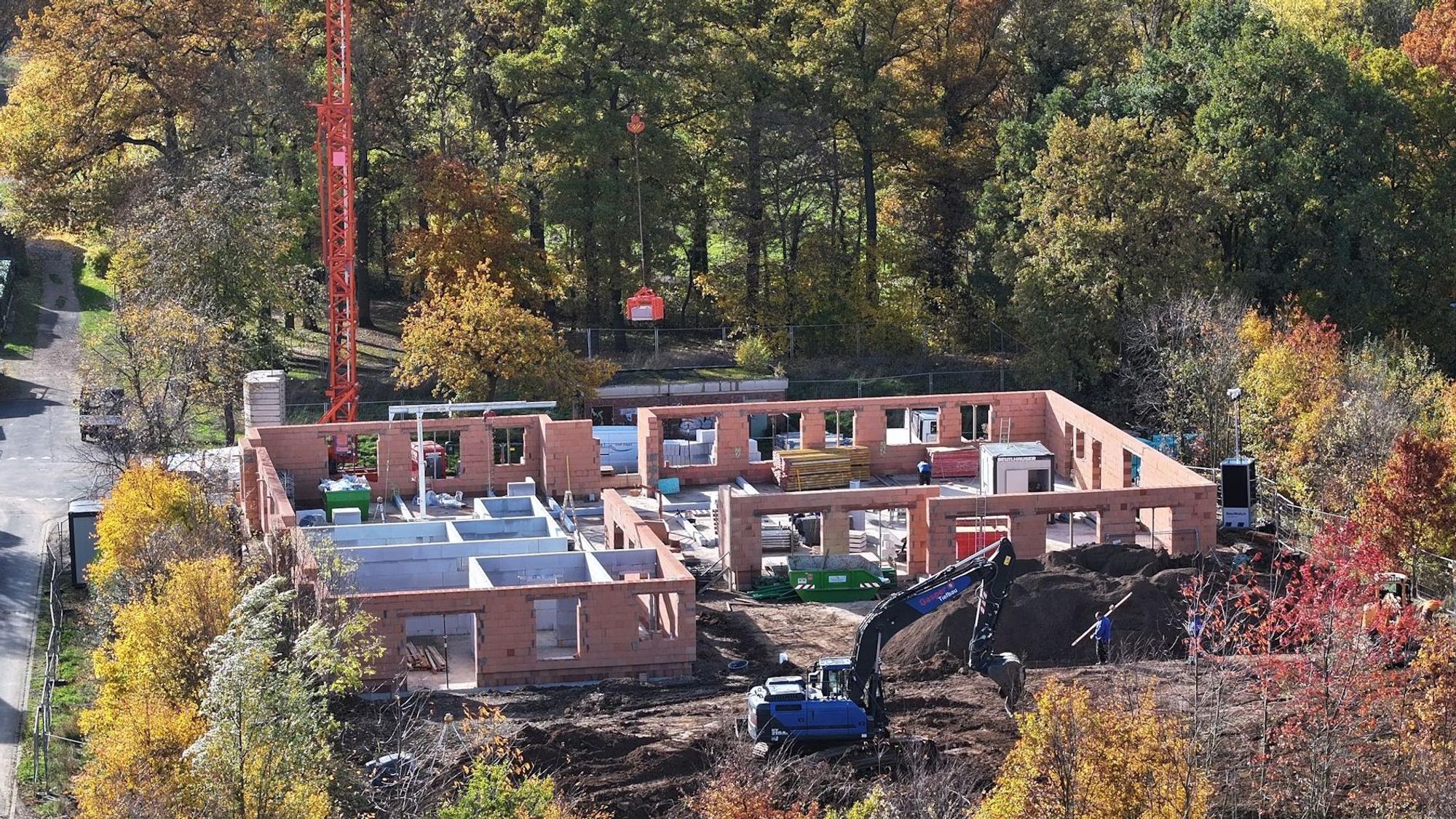 Eine Drohnenaufnahme von Baustelle, auf der die Außenmauern der Kita bereits stehen.
