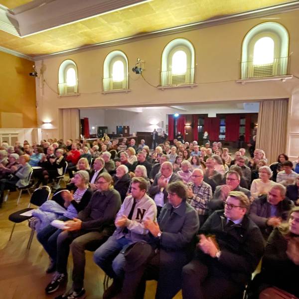Ein Blick in den Saal des Casinos, in dem das Publikum in Stuhlreihen sitzt.
