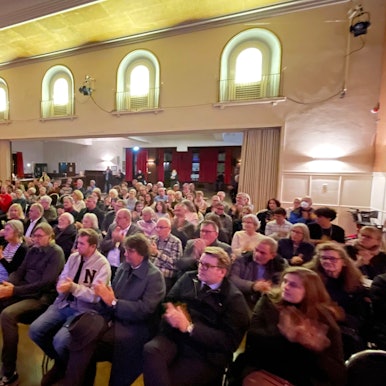 Ein Blick in den Saal des Casinos, in dem das Publikum in Stuhlreihen sitzt.